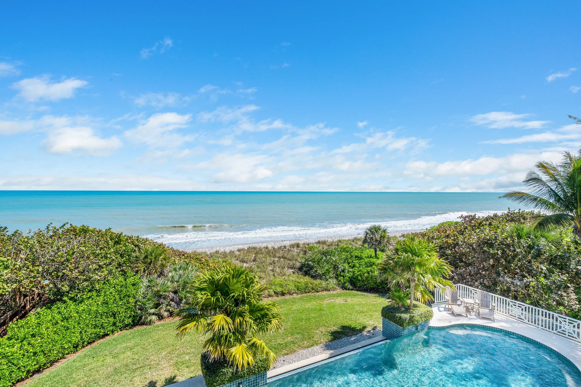 211 Beachside Drive seen from above: the rear elevation, infinity-edge pool and 122 feet of Atlantic shoreline in Orchid, FL