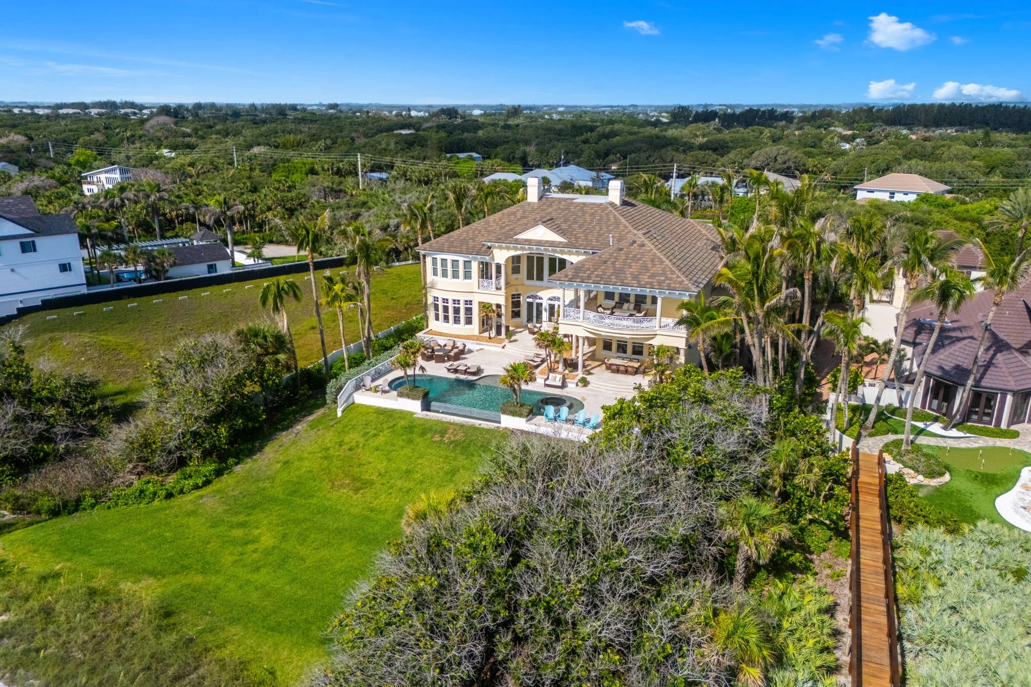Aerial of estate's rear elevation, pool, lawn, and boardwalk to Atlantic dune