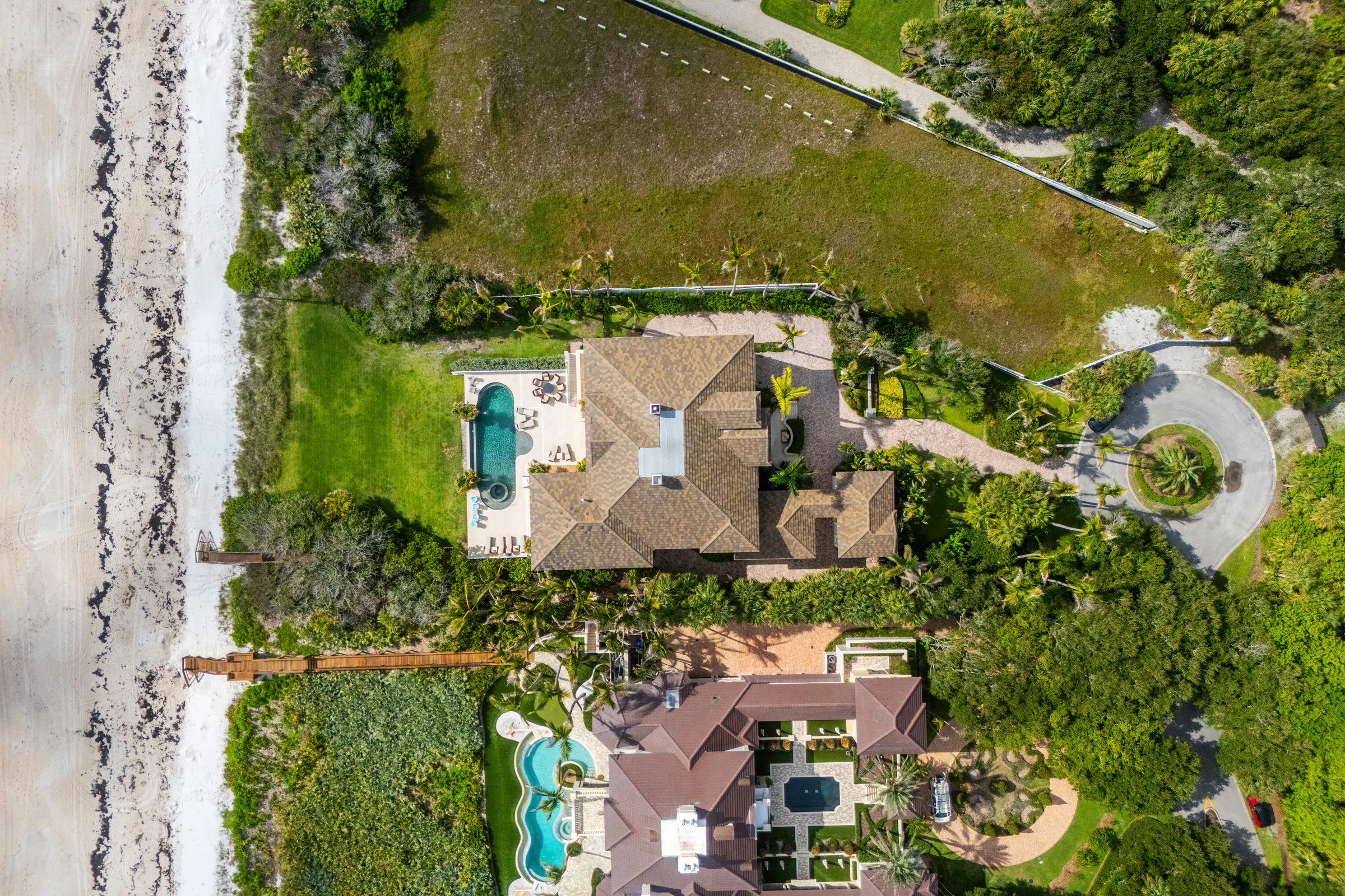 Top-down aerial showing infinity pool, dune boardwalk, and 122 feet of Atlantic shoreline at 211 Beachside Drive