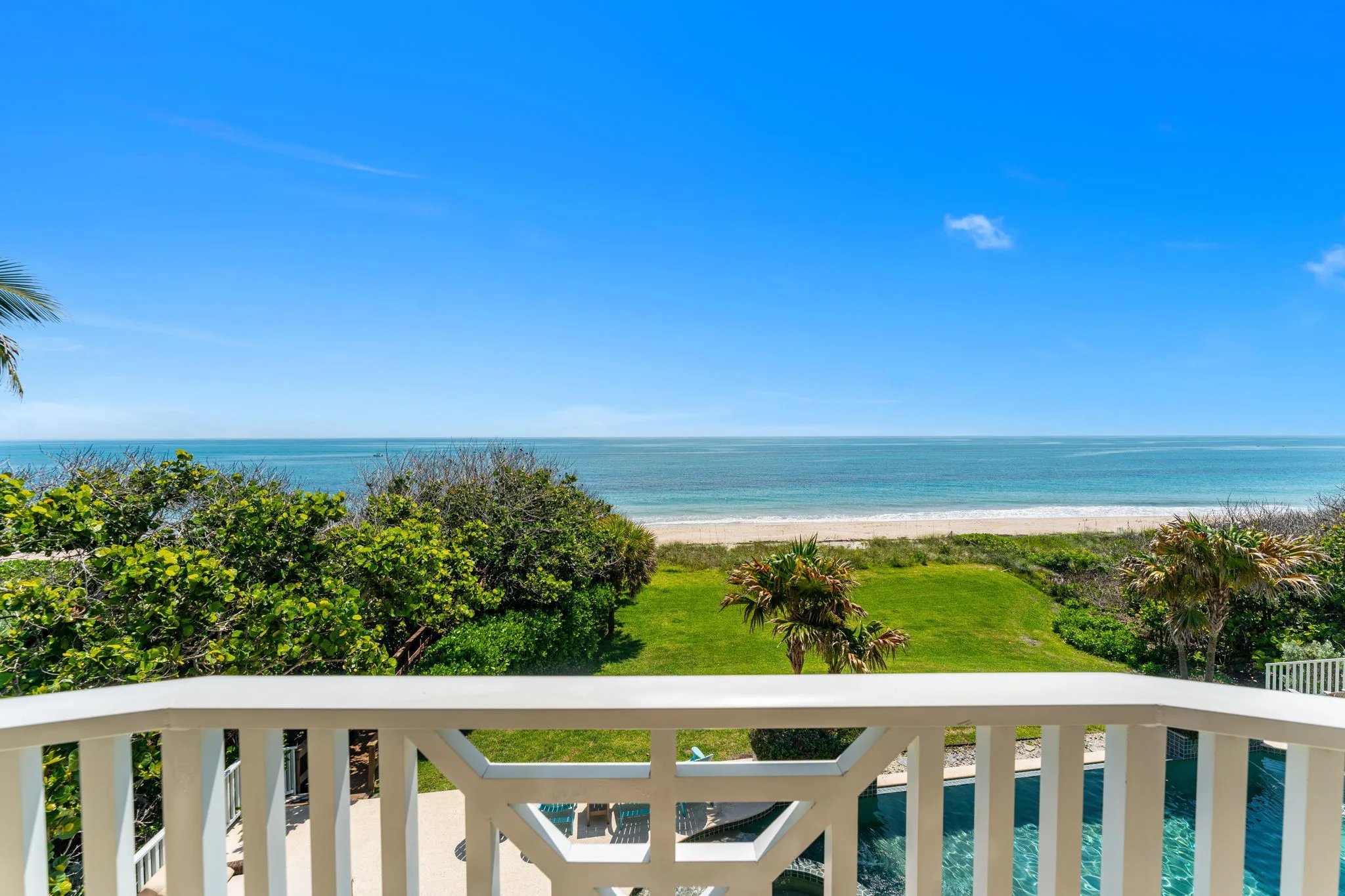 Upper balcony rail frames the pool deck below and the Atlantic horizon