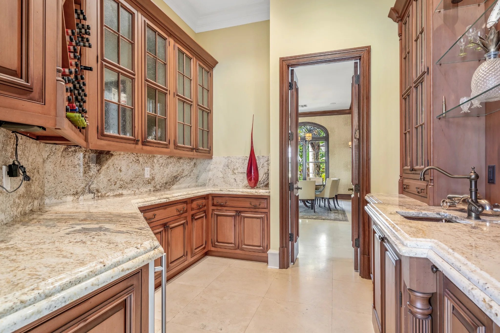 Butlers pantry with mahogany cabinetry, granite counters and wine storage to dining