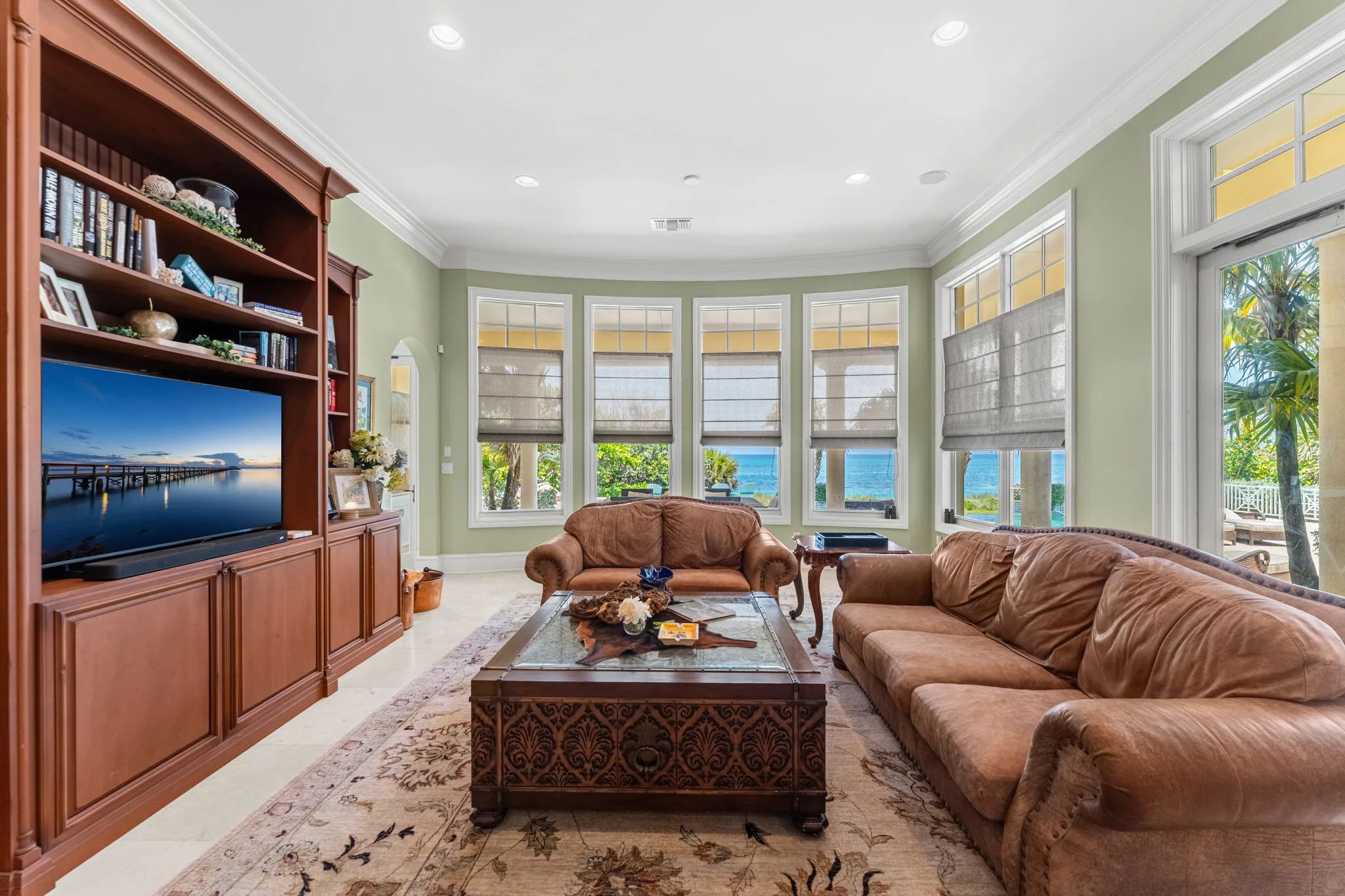 Family room with leather sofas, mahogany media wall, and bay-window ocean outlook