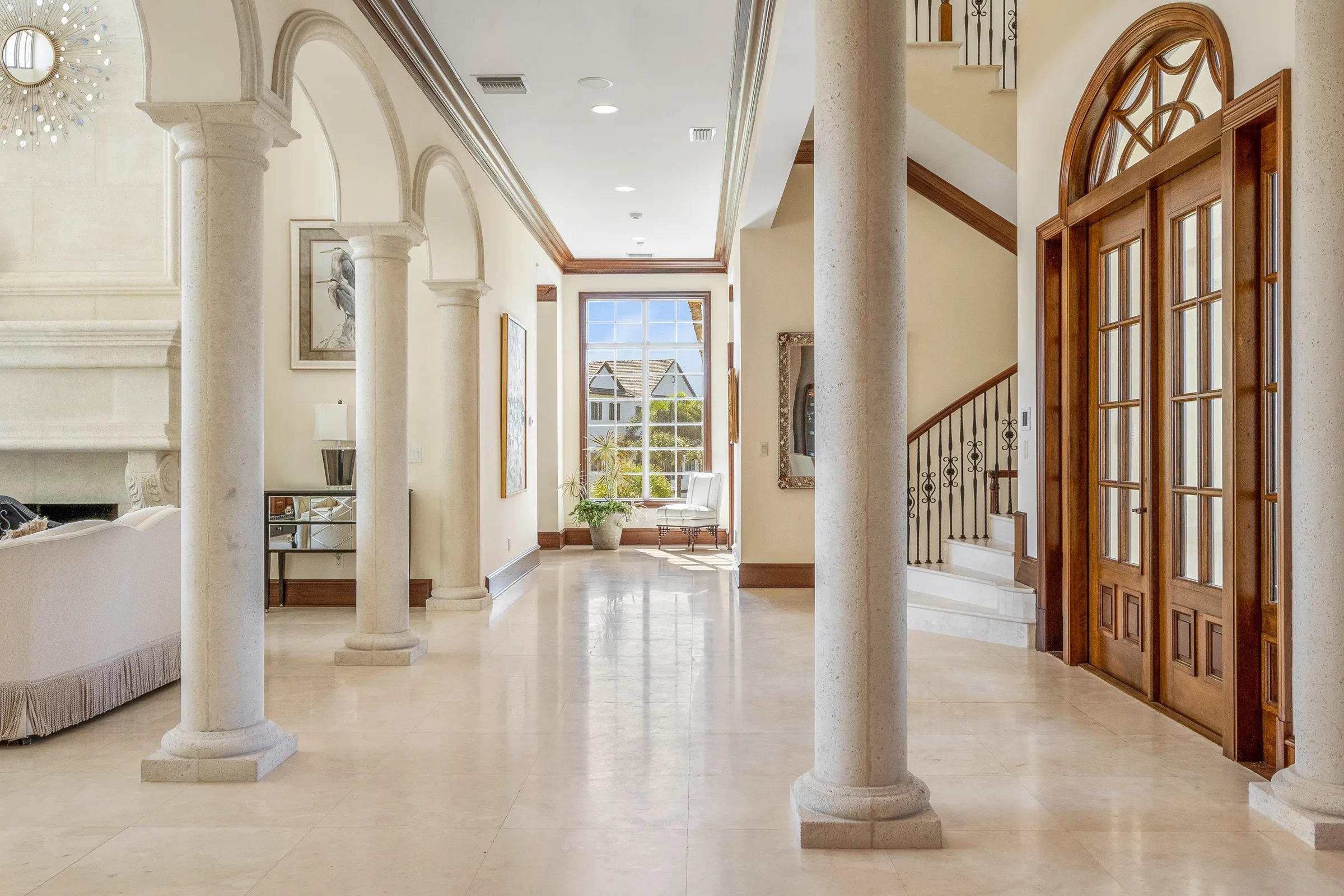 Signature arched arcaded gallery foyer with classical columns and marble floors at 211 Beachside Drive