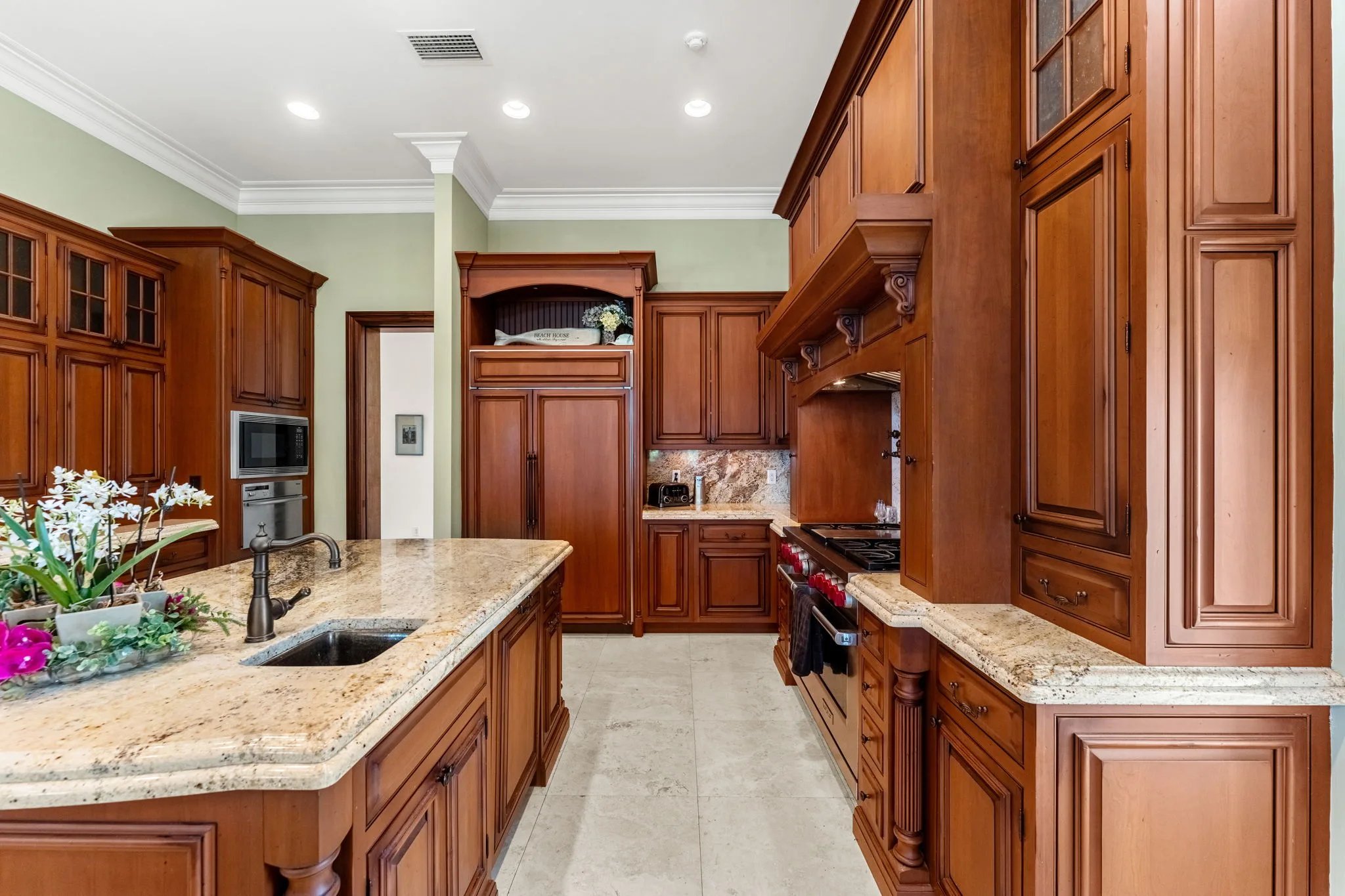 Cherry cabinetry and granite counters line the galley path past the range