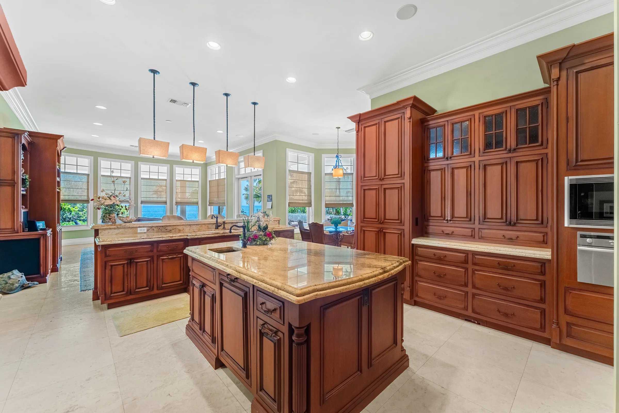 Twin granite islands face the Atlantic windows beneath linen pendants