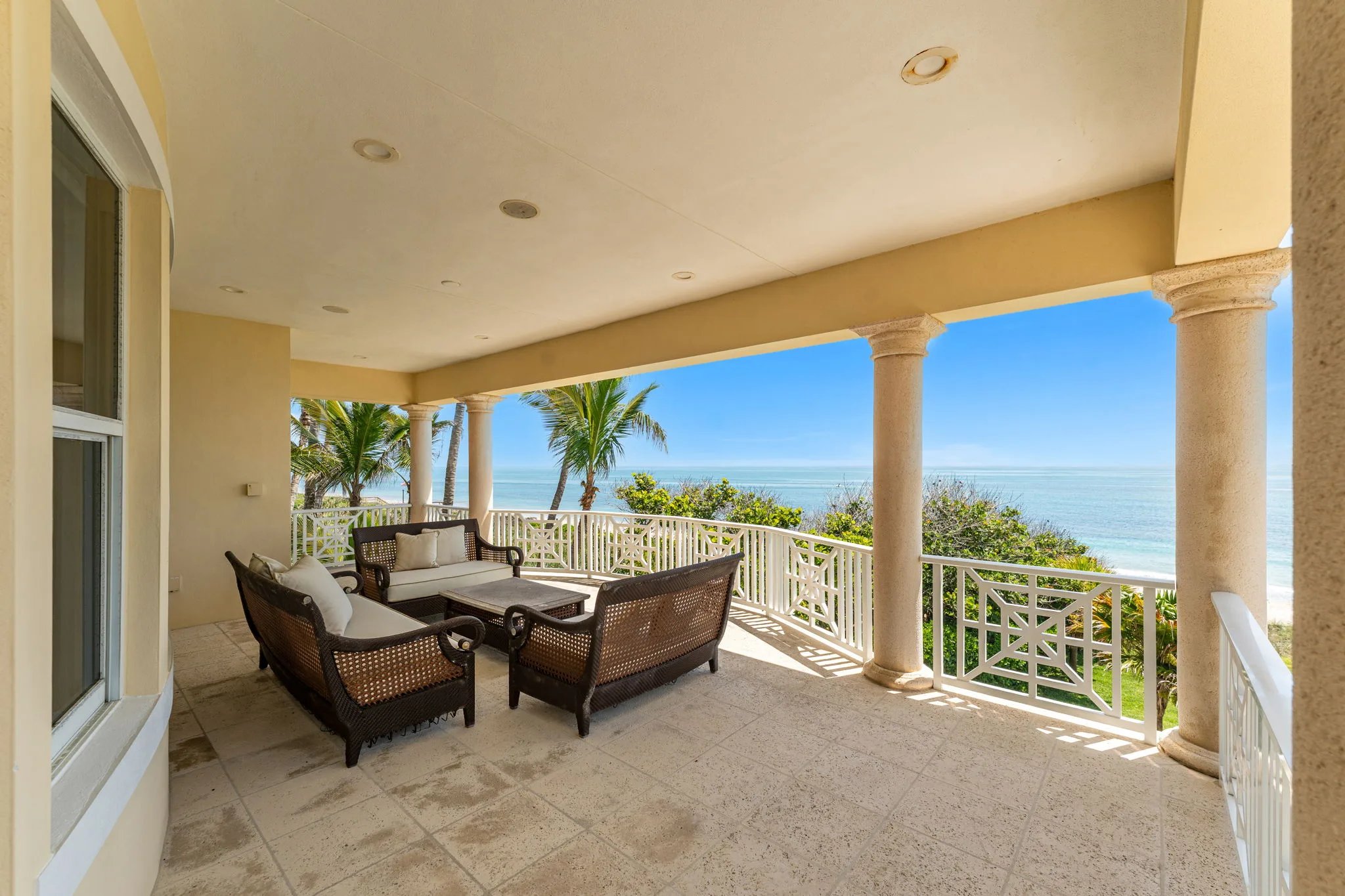 Columned upper porch with Chippendale rail opening to wide Atlantic horizon