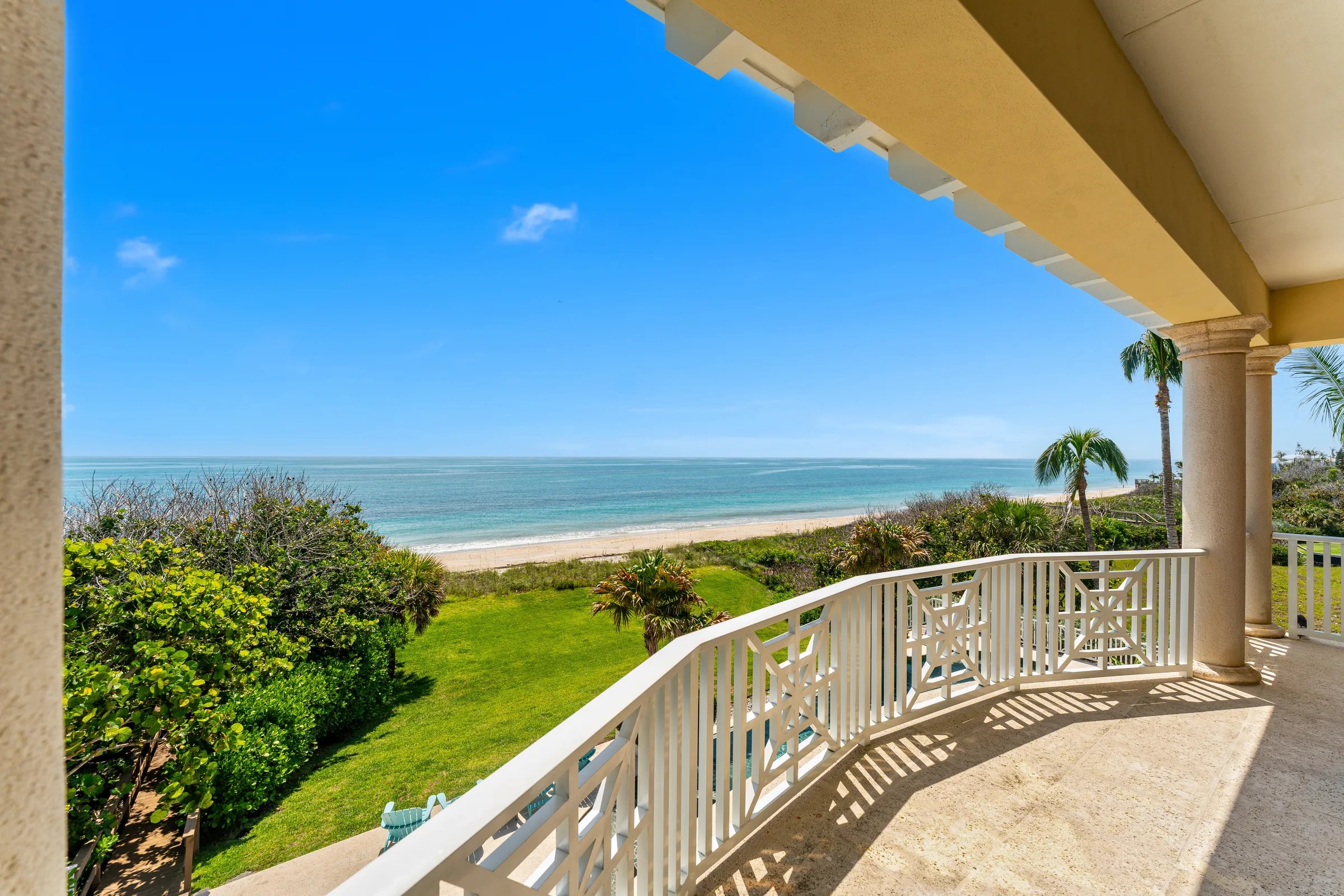Owner-suite covered porch with Chippendale rail and unbroken Atlantic horizon