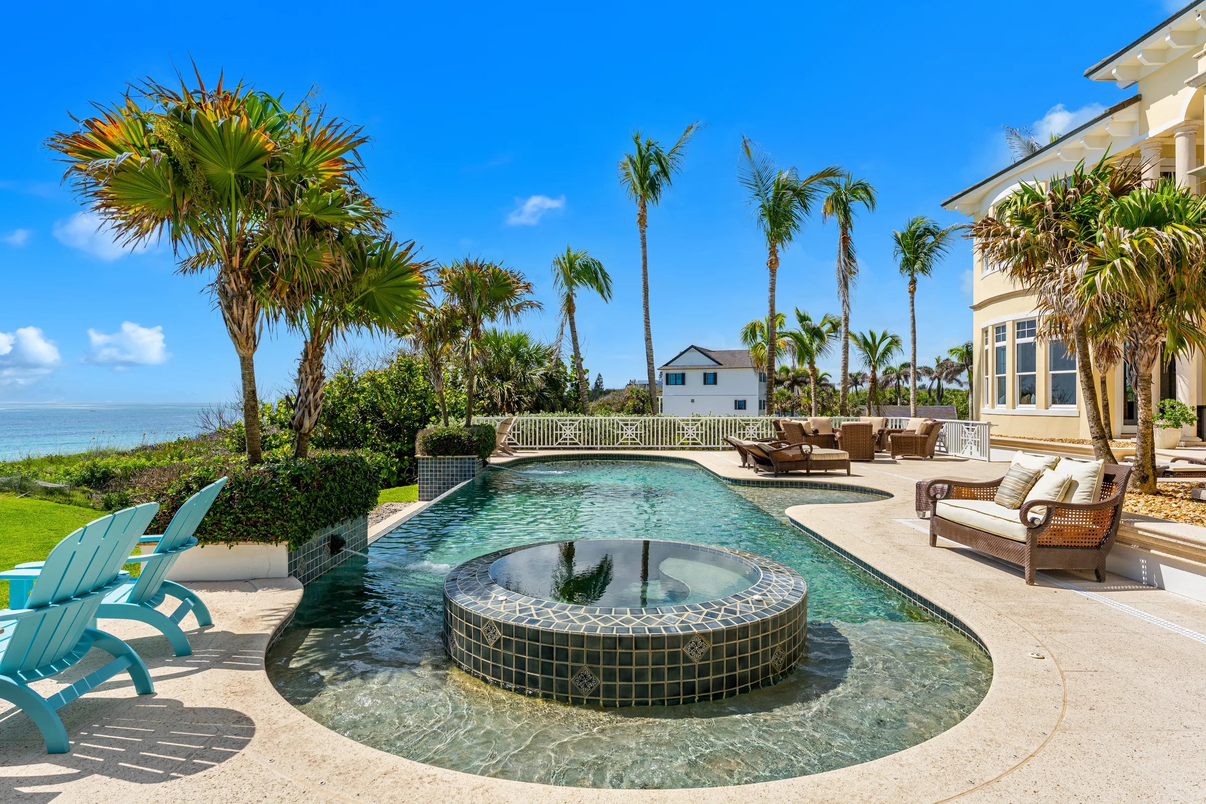 Infinity pool with mosaic-tiled raised spa, palms, and Atlantic horizon at 211 Beachside Drive in Orchid
