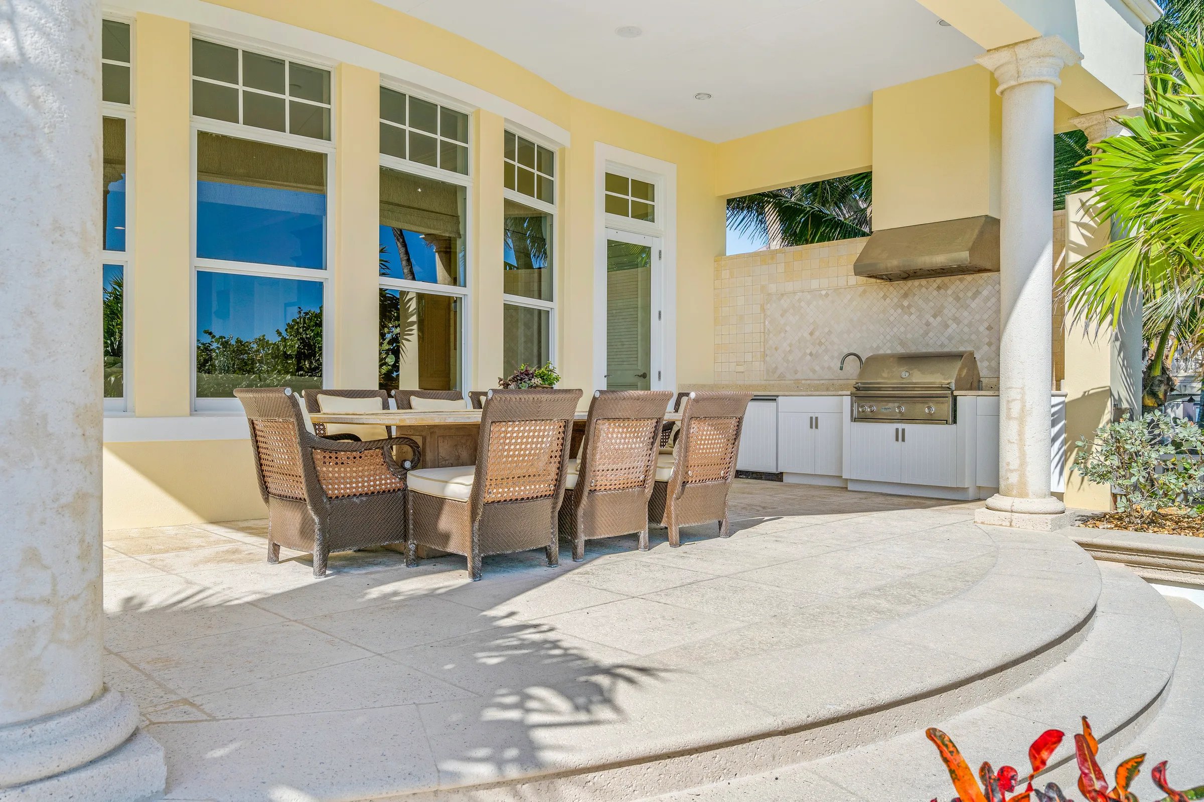 Covered lanai dining set with summer kitchen and grill behind